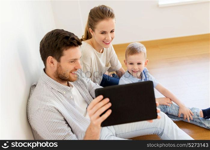 mortgage, people, housing and real estate concept - happy family with tablet pc computer moving to new home. happy family with tablet pc moving to new home