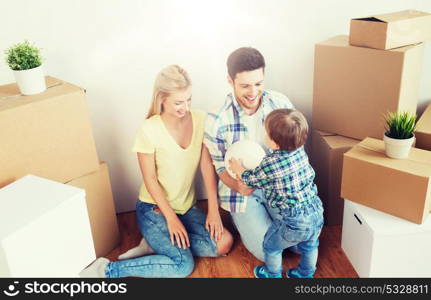 mortgage, people, housing, moving and real estate concept - happy family with boxes playing ball at new home. happy family moving to new home and playing ball