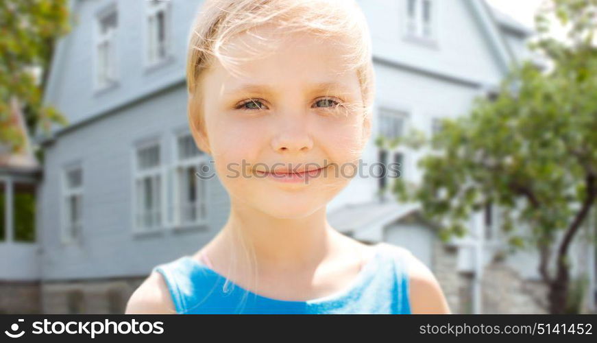 mortgage, real estate and childhood concept - happy little girl over living house background. happy little girl over living house background