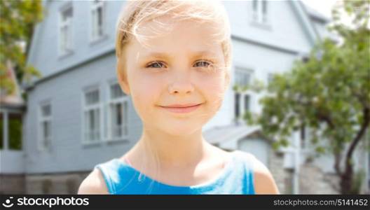 mortgage, real estate and childhood concept - happy little girl over living house background. happy little girl over living house background