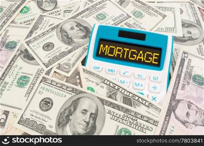 Mortgage word on calculator with hundreds of American notes