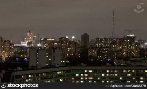 Moscow high angle aerial view industrial time lapse by night with cranes, car traffic and TV tower shot with long exposure with blurred car lights