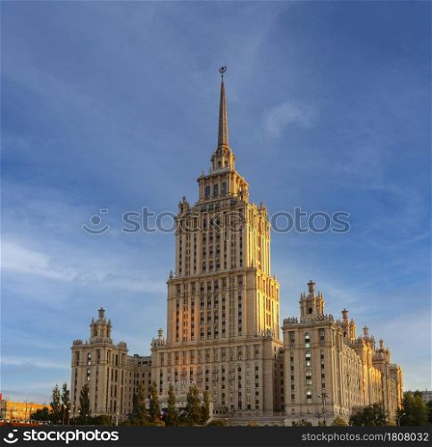 MOSCOW, RUSSIA - 12 JULY, 2021: Stalin era tower building of Ukraine hotel now occupied by luxury 5 star Radisson Royal Hotel panoramic detail vertical wide exterior view against dramatic blue sky. Stalin era tower building of Ukraine hotel now occupied by luxury 5 star Radisson Royal Hotel