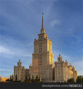 MOSCOW, RUSSIA - 12 JULY, 2021: Stalin era tower building of Ukraine hotel now occupied by luxury 5 star Radisson Royal Hotel panoramic detail vertical wide exterior view against dramatic blue sky. Stalin era tower building of Ukraine hotel now occupied by luxury 5 star Radisson Royal Hotel