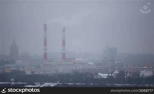 Moscow winter cityscape of Hamovniki district: buildings and a plant with smoking pipes