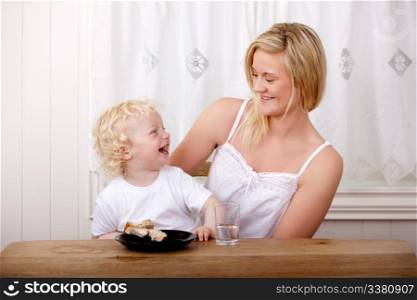 Mother a son laughing while eating lunch at a table