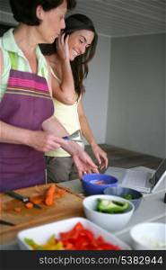 Mother and adult daughter cooking together