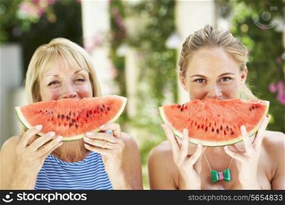 Mother And Adult Daughter Enjoying Slices Of Water Melon
