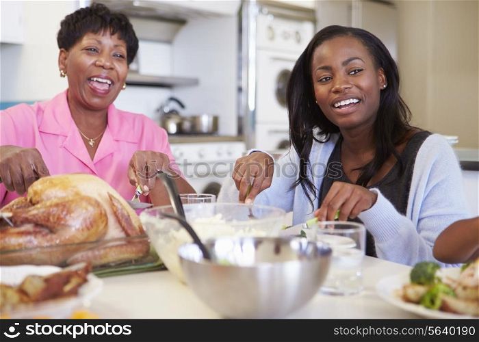 Mother And Adult Daughter Having Family Meal At Table