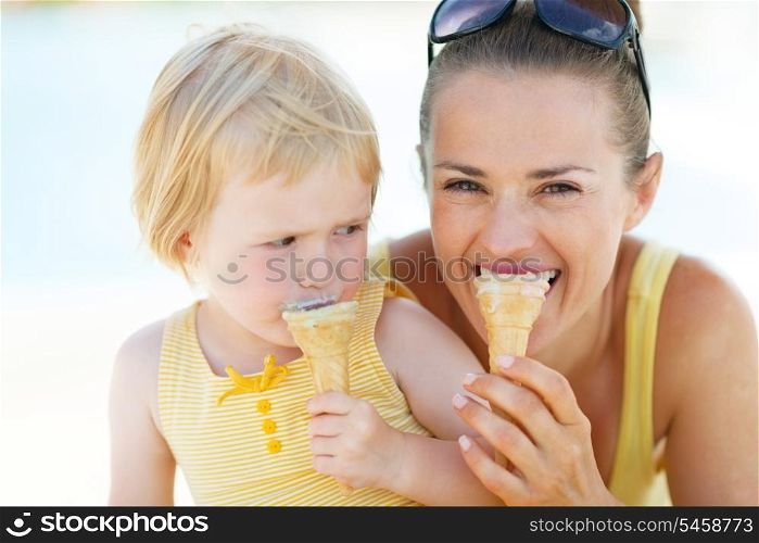 Mother and baby biting ice cream