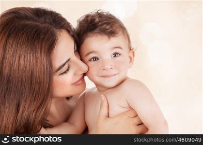 Mother and baby boy closeup portrait, happy faces over beige background, mom and kid having fun indoor, parents lifestyle, woman holding little child, healthy toddler and mommy, happiness concept