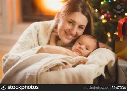 mother and baby boy in blanket posing in Christmas room
