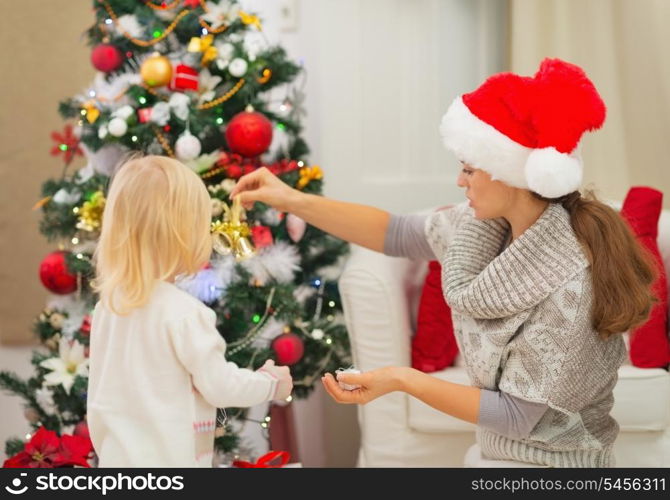 Mother and baby decorating Christmas tree