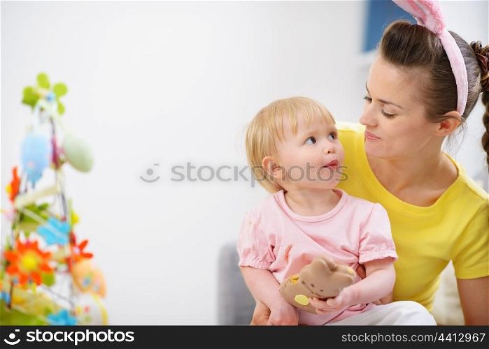 Mother and baby eating chocolate Easter rabbit cookie
