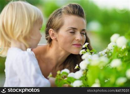Mother and baby enjoying flowers outdoors
