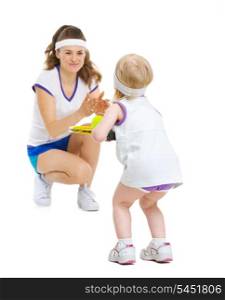 Mother and baby in tennis clothes playing tennis