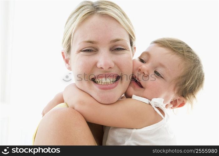 Mother and baby indoors hugging and smiling