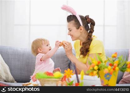 Mother and baby knocking Easter eggs