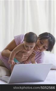 Mother and baby looking at laptop
