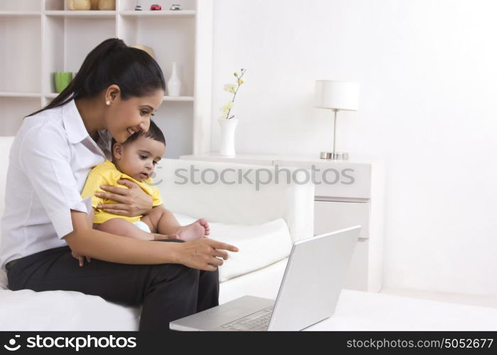 Mother and baby looking at laptop