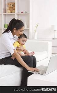 Mother and baby looking at laptop