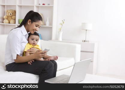 Mother and baby looking at mobile phone