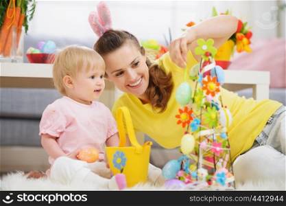 Mother and baby making Easter decoration