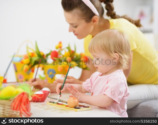 Mother and baby making Easter decorations