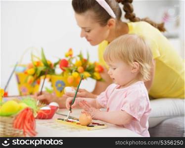 Mother and baby making Easter decorations