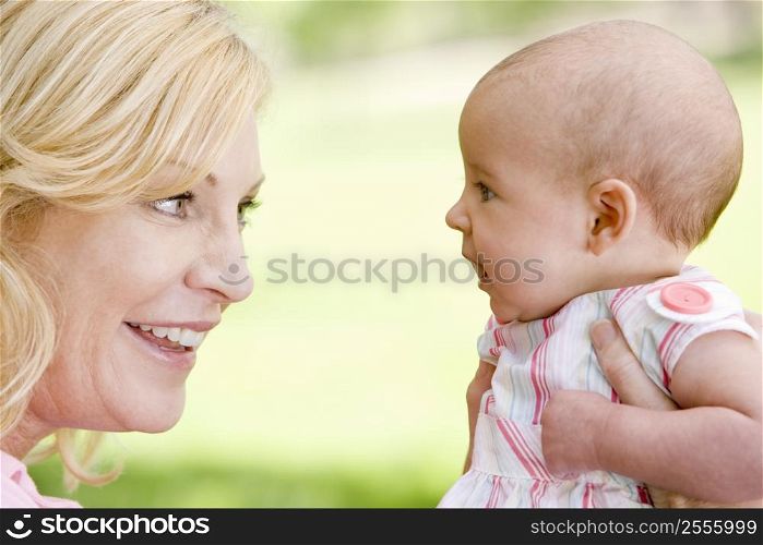 Mother and baby outdoors smiling