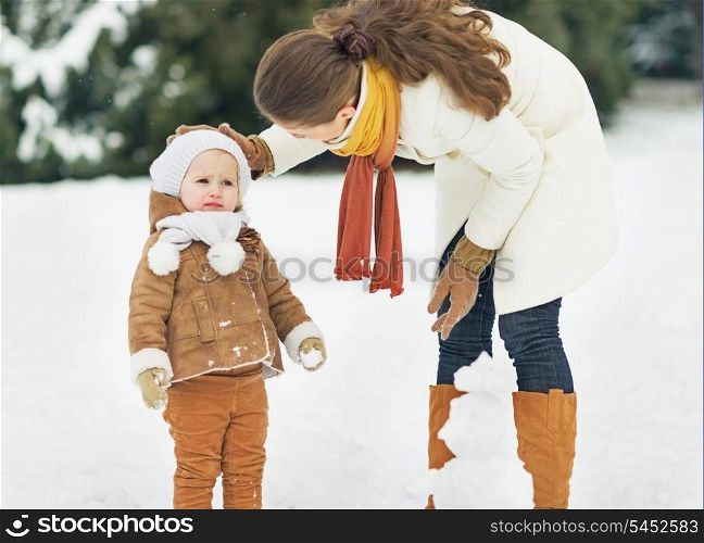 Mother and baby playing in winter outdoors