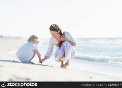 Mother and baby playing on beach