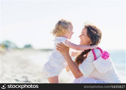 Mother and baby playing on sea shore