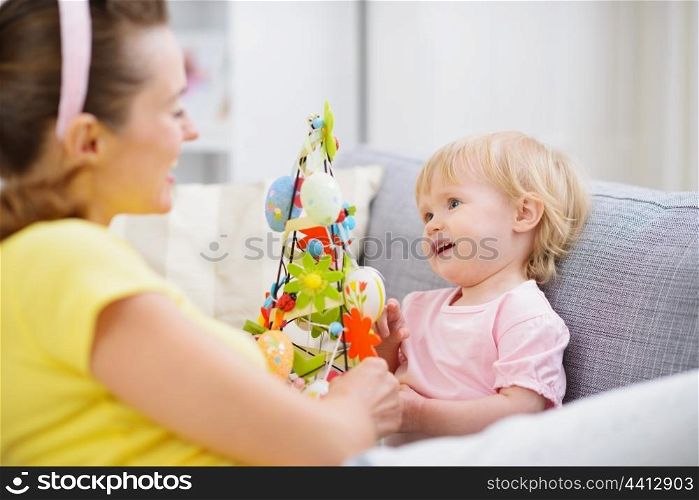 Mother and baby playing with Easter decoration