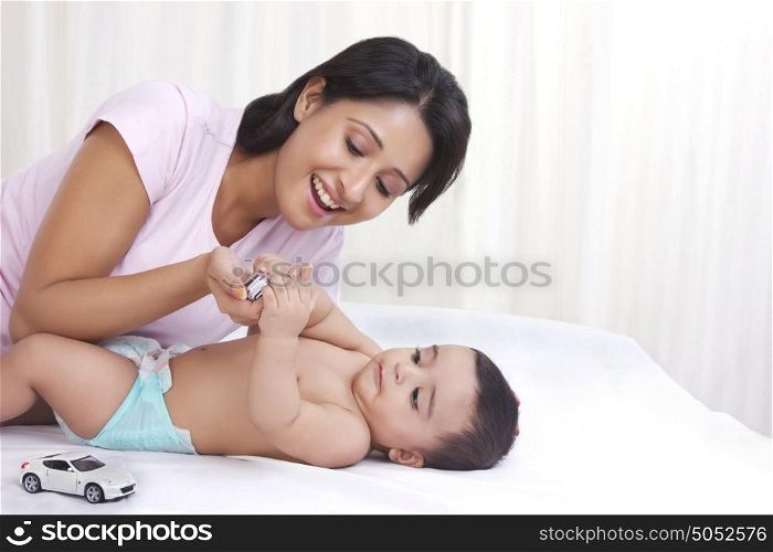Mother and baby playing with toy cars