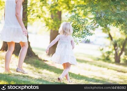 Mother and baby running in forest
