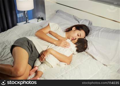 mother and baby sleeping on the bed at home