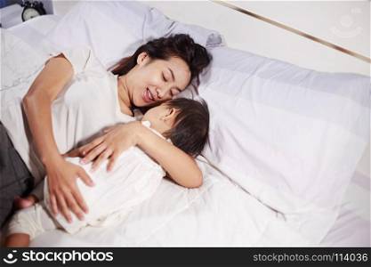 mother and baby sleeping on the bed at home