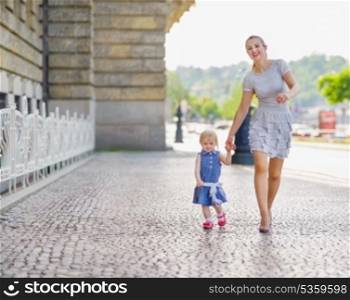 Mother and baby walking in city