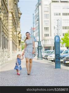 Mother and baby walking in city