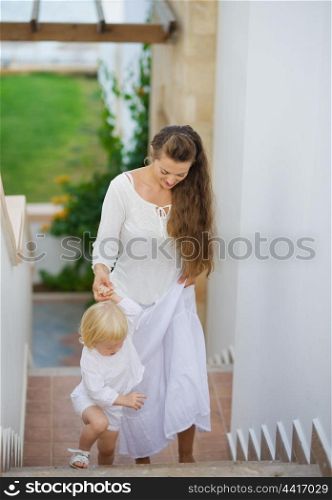 Mother and baby walking up stairs