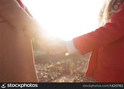 mother and child hands abstract sunset shot. Support and protection