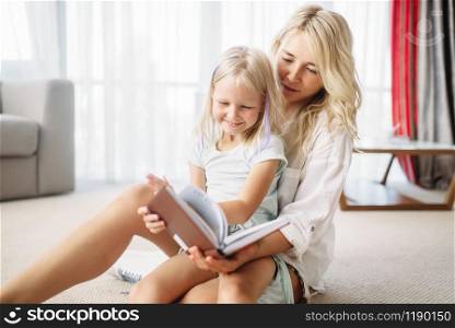 Mother and child have fun together lying on the floor at home. Parent feeling, togetherness
