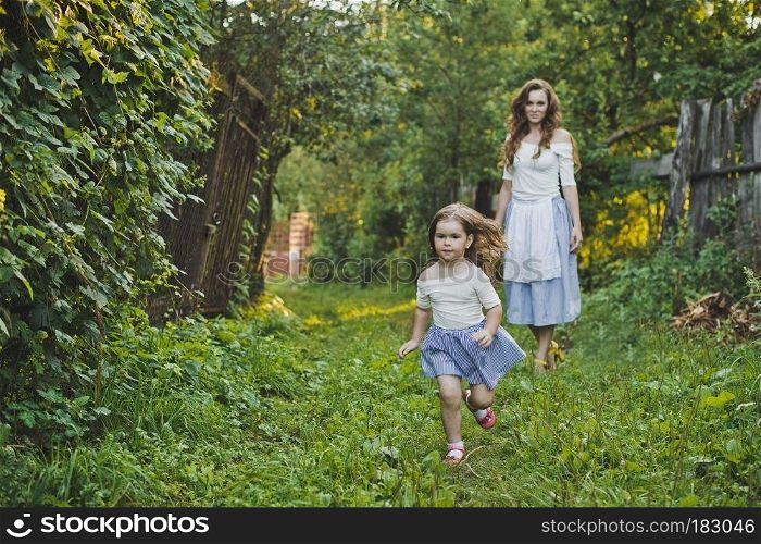 Mother and child having fun and playing in nature.. Mom and daughter laughing and playing in nature 4728.
