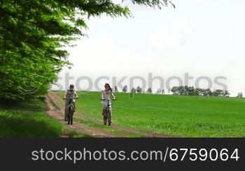 mother and child riding on a bicycle in a field