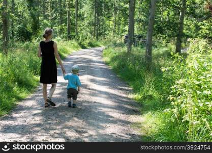 Mother and child walking in a forest. Mother and child walking in a forest in summer