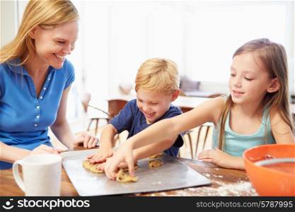 Mother And Children Baking Cookies Together At Home