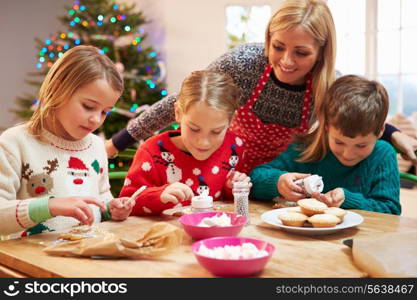 Mother And Children Decorating Christmas Cookies Together