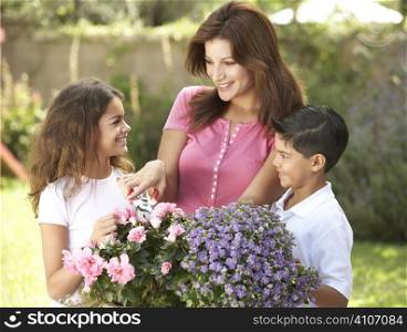 Mother And Children Gardening Together