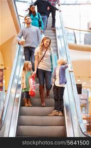 Mother And Children On Escalator In Shopping Mall